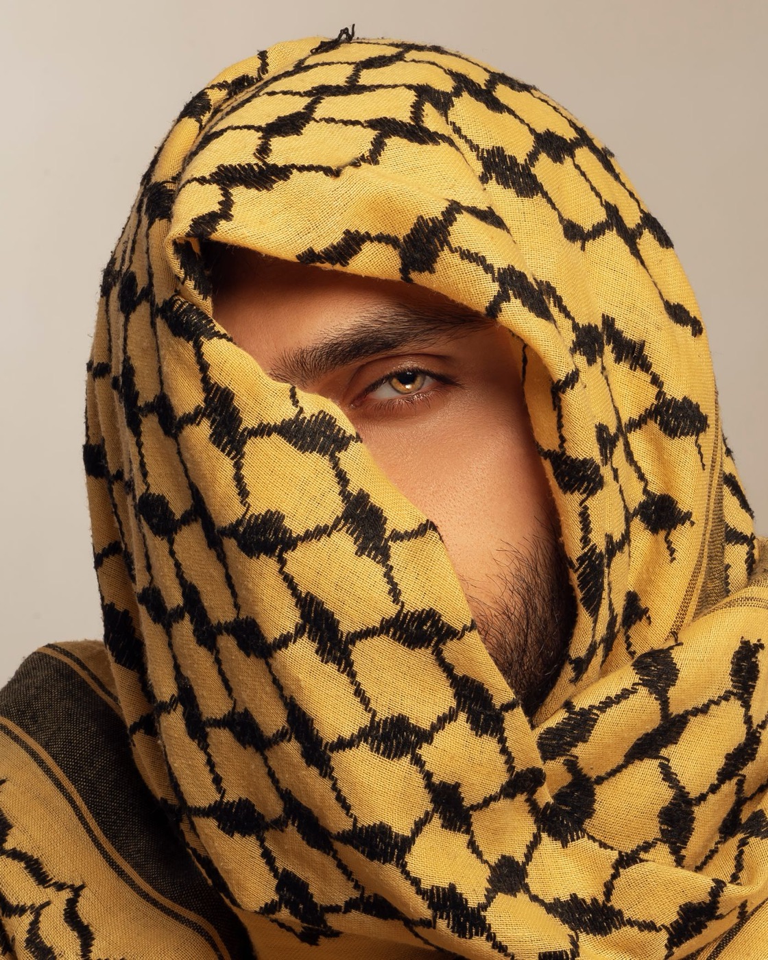 Portrait of a man wrapped in a yellow and black keffiyeh