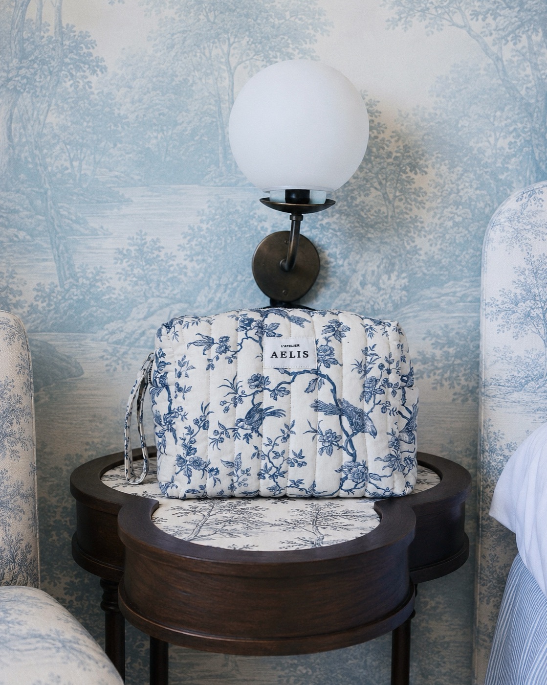 Atelier Aelis toile de Jouy vanity case on a bedside table